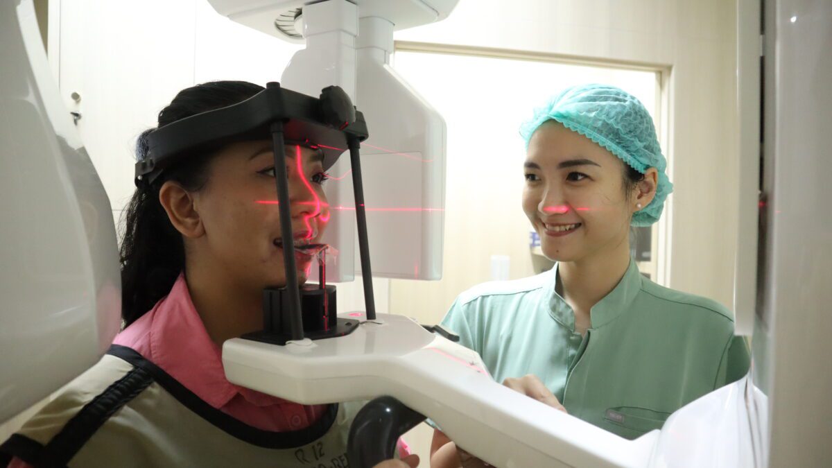Dokter gigi mendampingi pasien melakukan pemeriksaan dengan CBCT di Klinik Gigi dan Mulut RKZ Surabaya.